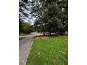 Lush lawn and mature trees accent the long driveway leading to the home at 3796 Melvin Sw Dr, Atlanta, GA 30331
