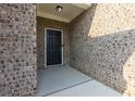 Inviting front entry featuring a solid black door, brick facade, and modern outdoor lighting at 740 Pineberry Ct, Grayson, GA 30017