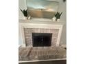 Close-up of a brick fireplace with a decorative mantle and hearth at 2303 Condor Dr, Lawrenceville, GA 30044