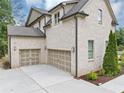 Angled view of the home's exterior highlighting the two-car garage and brick finish at 3459 Clubland Dr, Marietta, GA 30068