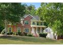 Two-story brick home features manicured lawn, charming green shutters, and natural surroundings at 4630 Smokestone Dr, Douglasville, GA 30135