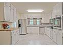 Bright kitchen featuring white cabinets, modern appliances, and stylish marble floors at 4025 Cheoah Dr, Douglasville, GA 30135
