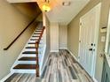 Inviting entryway with stylish wood-look tile flooring and staircase with white railings at 3988 Church View Ln, Suwanee, GA 30024