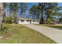 This single story home features a long driveway and beautiful lawn at 80 Crystal River Dr, Riverdale, GA 30274