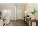 Bright entryway featuring hardwood floors, a console table with decor, and a view of the front door at 6510 Boulder Rdg, Cumming, GA 30028