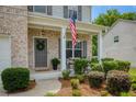 Inviting front porch with gray door, decorative wreath, and landscaped bushes along the walkway at 6510 Boulder Rdg, Cumming, GA 30028