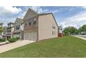 A side view showing the townhome's well-manicured lawn, sidewalk, and street access at 3137 Spicy Cedar Ln, Lithonia, GA 30038