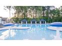 Large swimming pool with shaded cabanas, lounge chairs, and umbrellas, perfect for relaxation and recreation at 1159 Blue Juniper Cir, Loganville, GA 30052