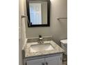 A charming bathroom with a granite countertop and a dark framed mirror at 233 Winterville Dr, Rockmart, GA 30153