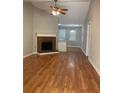Open living room with brick fireplace, ceiling fan and hardwood floors at 233 Winterville Dr, Rockmart, GA 30153