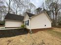 A view of the side of the home with clean vinyl siding, dark roof and manicured flower beds at 233 Winterville Dr, Rockmart, GA 30153