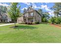 Traditional home featuring well-maintained lawn, mature trees, and attached two-car garage at 3483 Addilyn Ne Ct, Marietta, GA 30066