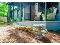 Charming front porch with outdoor seating, plants, and a decorative bird bath, adding to its appeal at 391 Buchanan St, Dallas, GA 30157