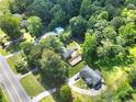 An aerial view showcases a property with dense tree cover and vehicle movement on the road at 14301 Veterans Memorial Highway, Villa Rica, GA 30180
