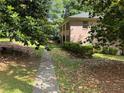 Brick home situated on a lot with mature trees and partial landscaping at 2315 Hudson Sw Dr, Lilburn, GA 30047