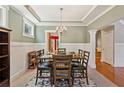 Formal dining room features a coffered ceiling, wainscoting and a chandelier above the dining table at 2185 Creole Cir, Cumming, GA 30040