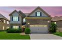 Charming two-story home featuring a brick facade, attached two-car garage, lush lawn, and manicured hedges at 2185 Creole Cir, Cumming, GA 30040