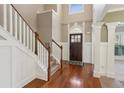 Bright foyer featuring hardwood floors, staircase and detailed trim work around the front door at 2185 Creole Cir, Cumming, GA 30040