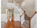 Spacious foyer with hardwood floors, staircase with white railings, and access to the living area at 2185 Creole Cir, Cumming, GA 30040