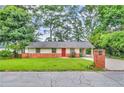 Inviting single-story home with brick accents, a bright red door, and a beautifully landscaped front yard at 3395 Spring Dr, Atlanta, GA 30360