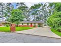 Charming home with brick accents and a long driveway leading to a covered carport, offering ample parking at 3395 Spring Dr, Atlanta, GA 30360