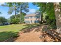 Beautiful two-story home with lush landscaping, mature trees, and a park bench at 3999 Brintons Ml, Marietta, GA 30062