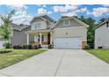 Charming two-story home features a covered front porch and attached two car garage at 7760 Hansel Ln, Lithonia, GA 30058