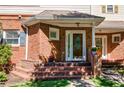Close-up of a lovely brick front porch with a charming front door and well-maintained landscaping at 8650 Hope Mews Ct, Sandy Springs, GA 30350