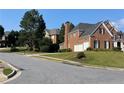 Beautiful two-story brick home featuring an attached garage, manicured landscaping and a chimney at 2123 Floral Ridge Dr, Dacula, GA 30019
