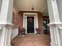 Charming front porch with brick flooring, decorative door, and white support columns at 2123 Floral Ridge Dr, Dacula, GA 30019