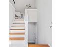 Bright staircase featuring hardwood stairs and white risers leading to a kitchen area at 5950 Milligan Ct, Atlanta, GA 30349