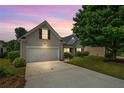 Charming home exterior at dusk, featuring a two-car garage and landscaped yard at 1028 Southwood Dr, Villa Rica, GA 30180