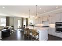 Open kitchen featuring a large center island, pendant lighting, stainless steel appliances, and hardwood flooring at 2905 Medford Drive, Cumming, GA 30041