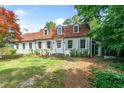 Classic two-story home with white siding, a brick roof, shutters, and mature landscaping at 1482 N Decatur Ne Rd, Atlanta, GA 30306