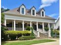 Elegant home featuring a covered front porch with stately columns, stone stairs, and meticulously maintained landscaping at 100 Trotters Ridge, Fayetteville, GA 30215