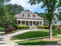 Beautiful home with a welcoming front porch, lush green lawn, mature trees, and a convenient circular driveway at 100 Trotters Ridge, Fayetteville, GA 30215