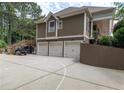 Exterior view showcasing a three-car garage, basketball court, and a stairway leading to an upper deck at 100 Trotters Ridge, Fayetteville, GA 30215