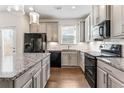 Modern kitchen boasts granite countertops, stainless steel appliances, gray cabinetry, and a functional layout at 2309 Rolling Trl, Lithonia, GA 30058