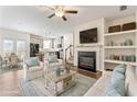 Bright living room with fireplace, built-in shelves, ceiling fan, hardwood floors, and opens to the kitchen at 2309 Rolling Trl, Lithonia, GA 30058