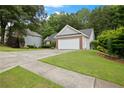 Well-manicured front yard with an attached two-car garage and gray vinyl siding, offering great curb appeal at 1027 Regency Dr, Acworth, GA 30102