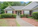 Inviting front entrance featuring a brick facade, manicured landscaping, and a clear walkway leading to the door at 1027 Regency Dr, Acworth, GA 30102