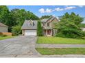 Charming two-story home featuring a stone and vinyl facade, two-car garage, and well-manicured lawn at 2004 Spicers Ln, Woodstock, GA 30189