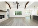 Bright living room featuring vaulted ceilings, exposed beams, a brick fireplace, and modern lighting at 2117 Ella Springs Dr, Covington, GA 30014