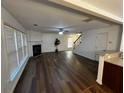 Open-concept living room showcasing hardwood floors, a cozy fireplace, and a staircase leading to the upper level at 3613 Tinsley Sw Way, Atlanta, GA 30331