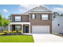 Charming two-story brick home featuring a well-manicured lawn and attached two-car garage at 3993 Makeover Ct, South Fulton, GA 30349
