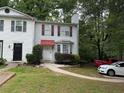 Charming two-story townhome with red shutters, a walkway, and well-maintained landscaping at 1104 Huntington Se Trce, Smyrna, GA 30082