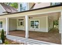 Spacious covered porch with stylish columns, ceiling fan, and wood flooring at 159 S Forest S Ave, Social Circle, GA 30025