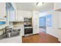 Functional kitchen featuring stainless steel appliances, white cabinets, and a view into an adjacent living area at 1526 Tanglewood Nw Way, Conyers, GA 30012