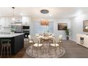 Charming dining area featuring a round table, modern chandelier, and seating for six, adjacent to the kitchen at 1582 Pine Cir, Austell, GA 30168