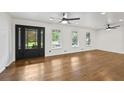 Bright living room with hardwood floors, large windows, ceiling fans, and a modern front door with glass panels at 1582 Pine Cir, Austell, GA 30168